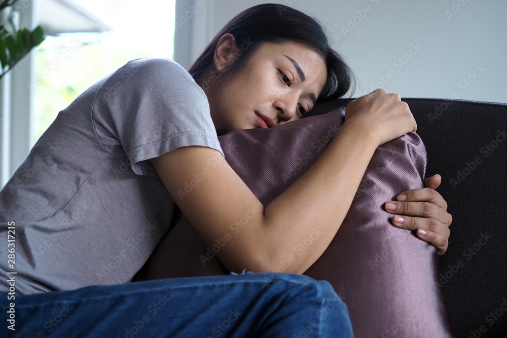 Obraz premium Asian women sitting on the couch. Women are confused, disappointed, sad and sad.