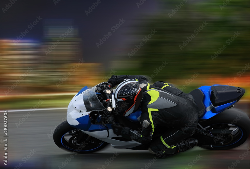 Racing bike rider leaning into a fast corner at high speed with motion blur