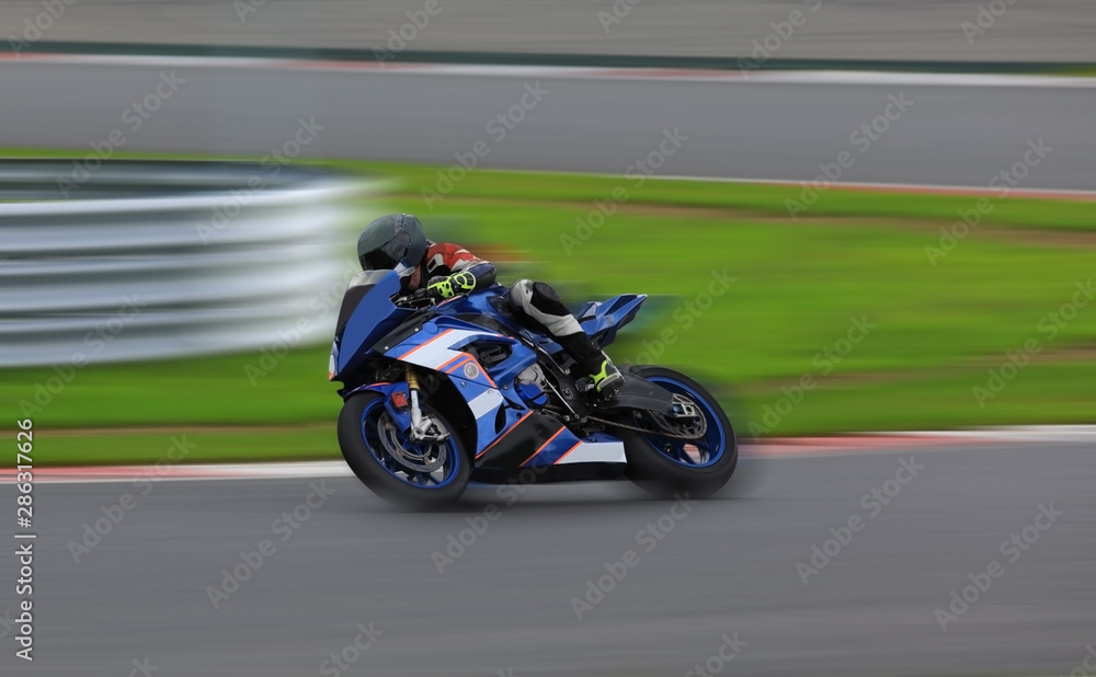 Racing bike rider leaning into a fast corner at high speed