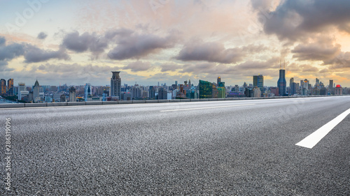 Empty highway and city skyline with buildings at sunset in Shanghai,China.