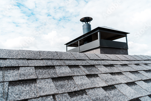 Fototapet selective focus of modern chimney on rooftop of house