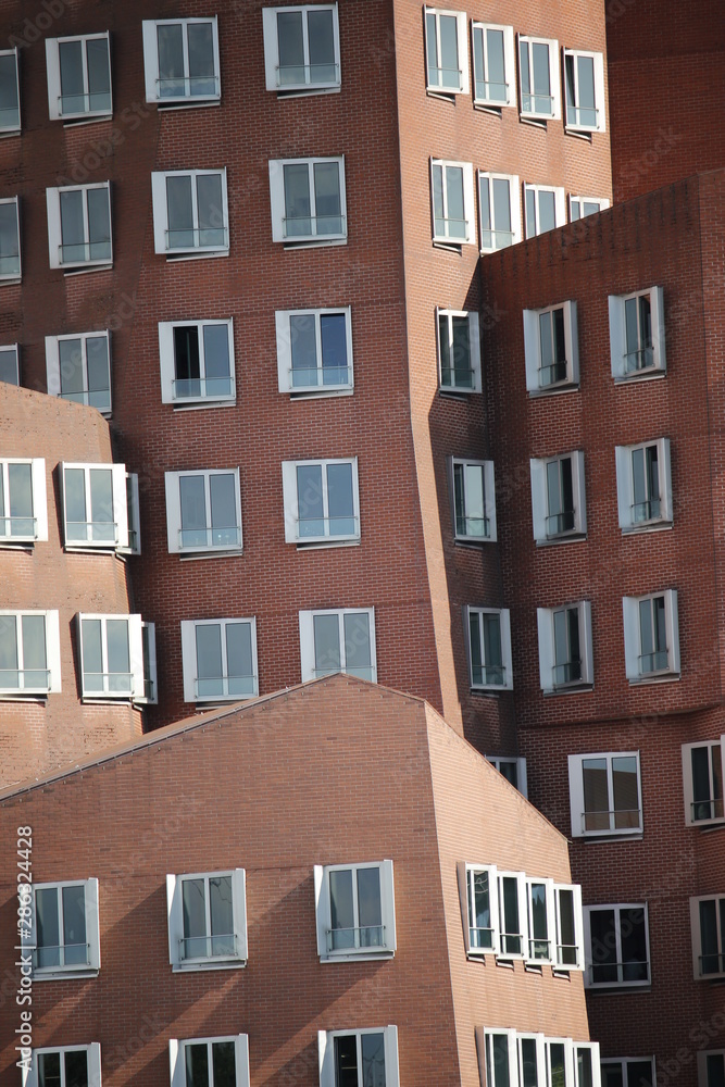 brown interleaved fassade with white windows of the Ghery buildings  