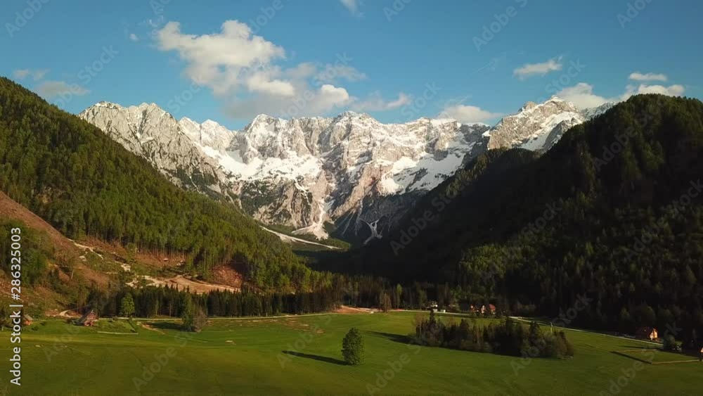 Forward drone shot of the Kamnik-Savinja Alps, Slovenia, covered in green forests and bright fields, on a sunny day Forward drone shot of the Kamnik-Savinja Alps, Slovenia, covered in green forests and bright fields, on a sunny day