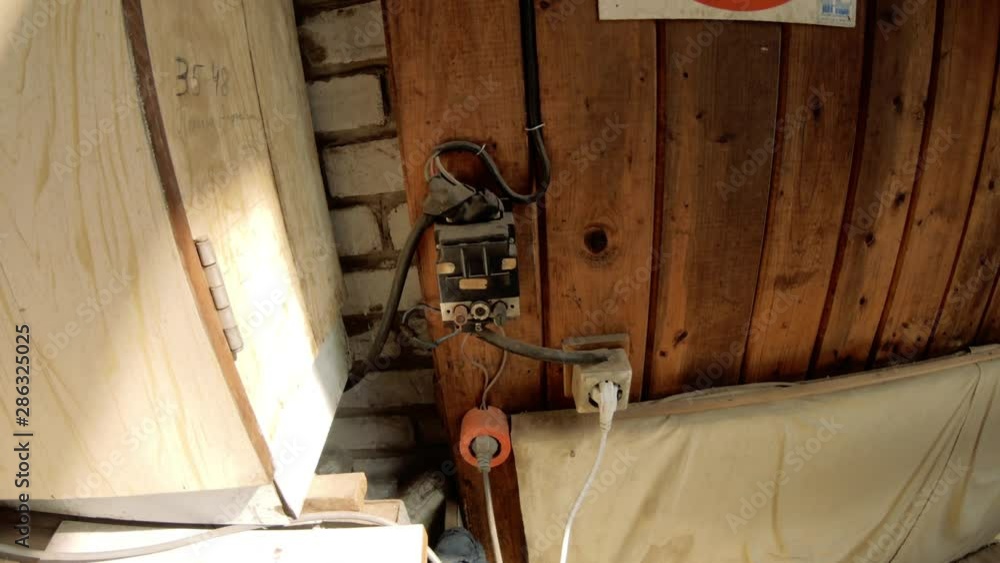 Outdated electrical switchboard and control buttons. A man turns on or ...