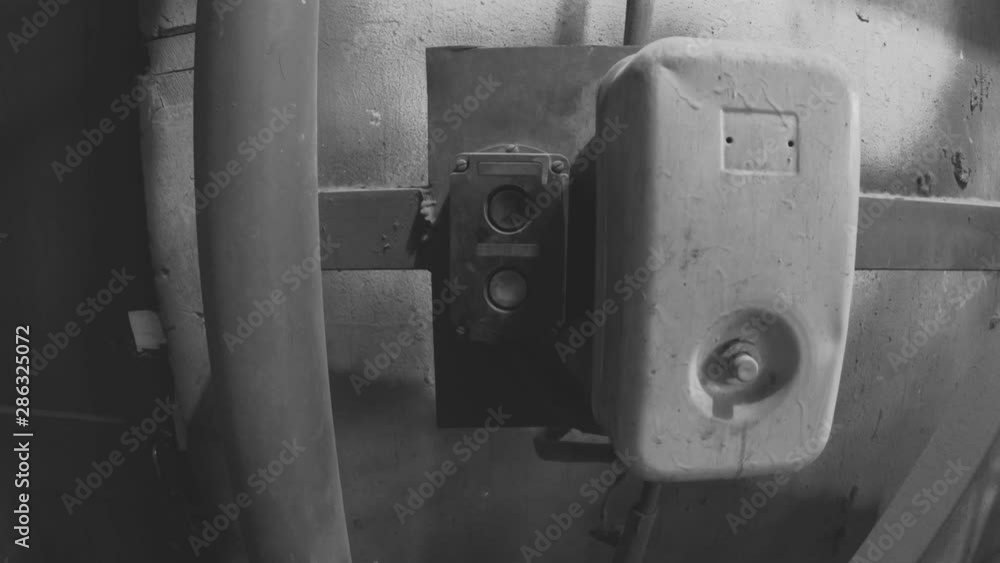 Outdated electrical switchboard and control buttons. A man turns on or ...