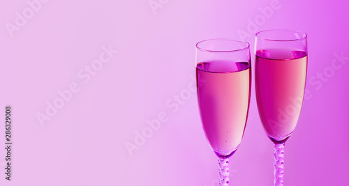 Sparkling New Year on the pink neon background with champagne. Christmas and happy new year 2020 concept. Copy space.