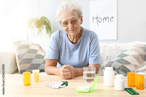 Elderly woman with medicines at home