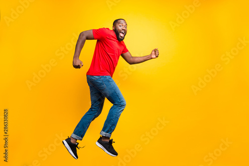 Full length body size photo of running man seeming to have done something bad and now trying to hide while isolated with yellow background
