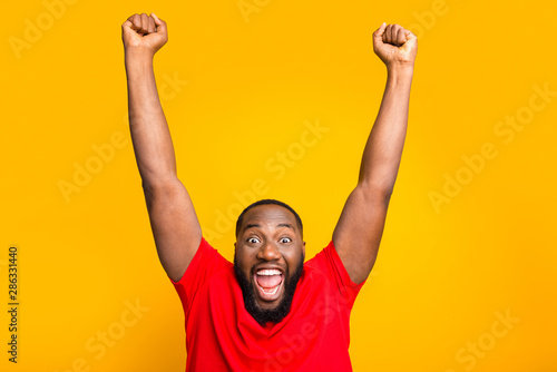 Photo of rejoicing enjoying happy american man screaming with pleasure while isolated with yellow background photo