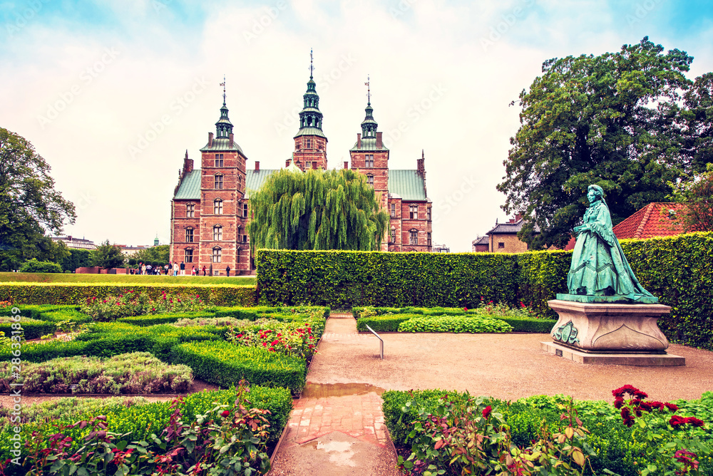 Breathtaking magical landscape with statue of Queen Caroline Amalie in the park of famous Rosenborg Castle in Copenhagen, Denmark. Exotic amazing places. Popular tourist atraction.