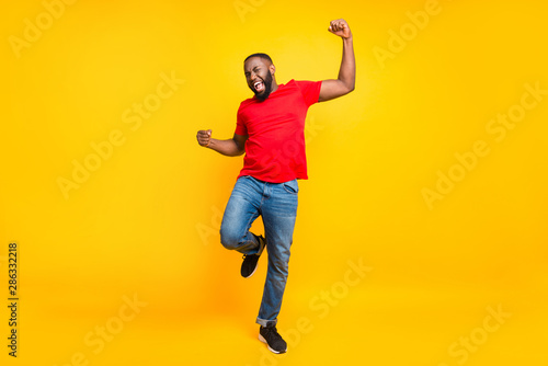 Full length body size photo of rejoicing glad cheerful happy black man dancing with joy while isolated with yellow background