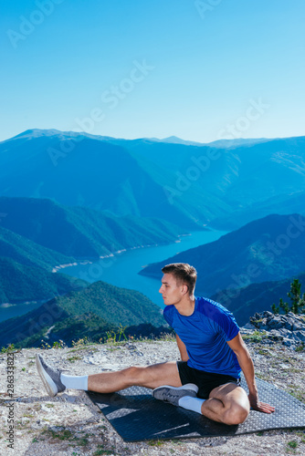 Athlete, long distance runner stretching his legs in nature.Getting ready for a run.