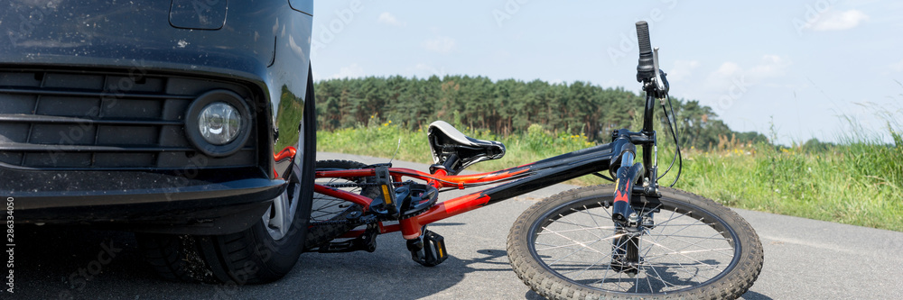 Obraz premium Children's bicycle accident with car on the street. Panoramic image