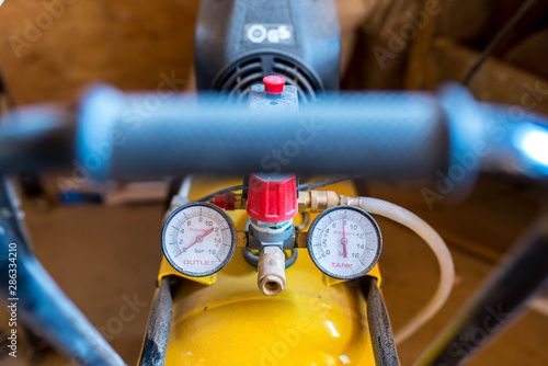 Quadro su tela Dusty manometers on air compressor in a small carpentry work shop