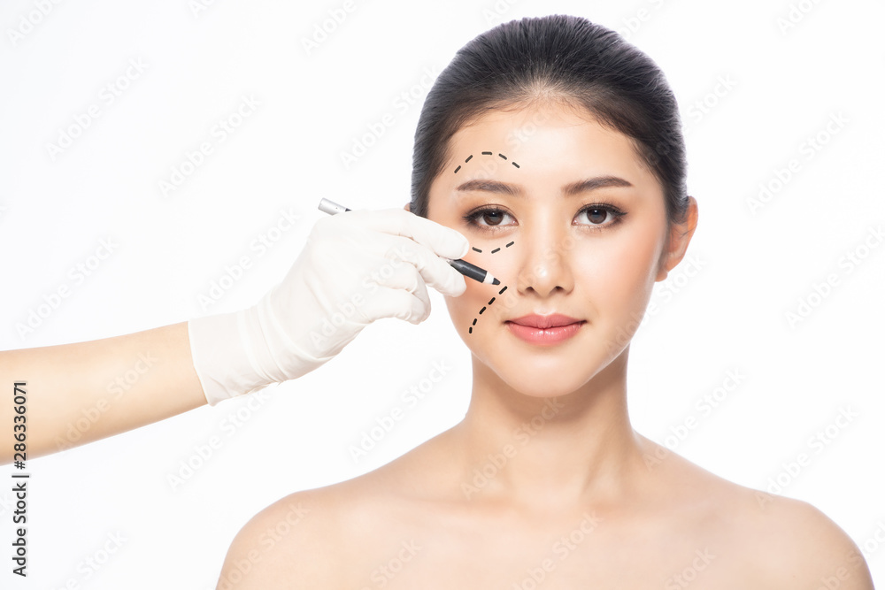 Lines on face, close up, plastic surgery concept, doctor's hand in glove making marks on patient's face..Asian beauty Woman in beauty salon. plastic surgery clinic. Lines on face, close up, plastic surgery concept, doctor's hand in glove making marks on patient's face..Asian beauty Woman in beauty salon. plastic surgery clinic.