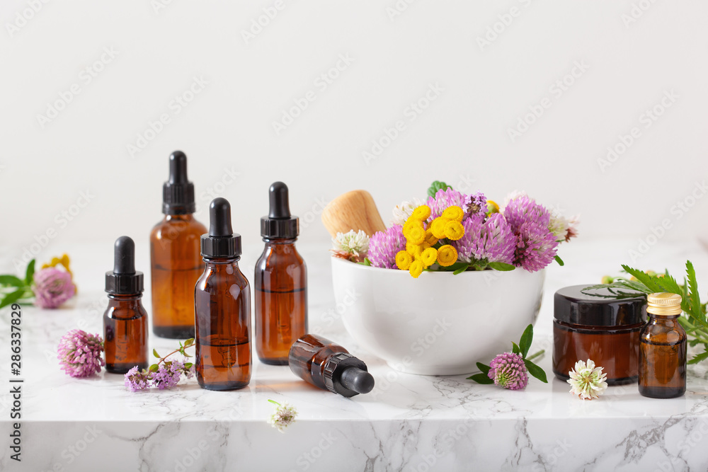 medical flowers herbs in mortar essential oils in bottles. alternative medicine. clover milfoil tansy rosebay - obrazy, fototapety, plakaty 