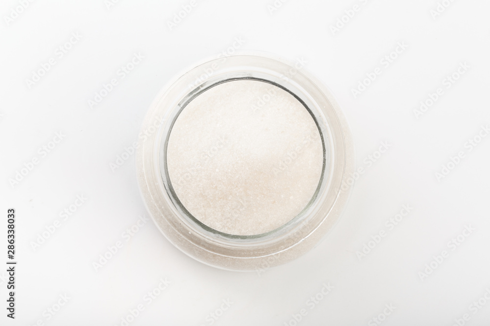 Sugar in glass bowl on white background top view Sugar in glass bowl on white background top view