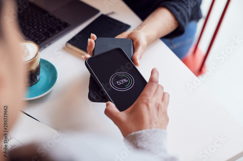 Two Mobiles Phone To Phone Wirelessly Charging On Desk photo