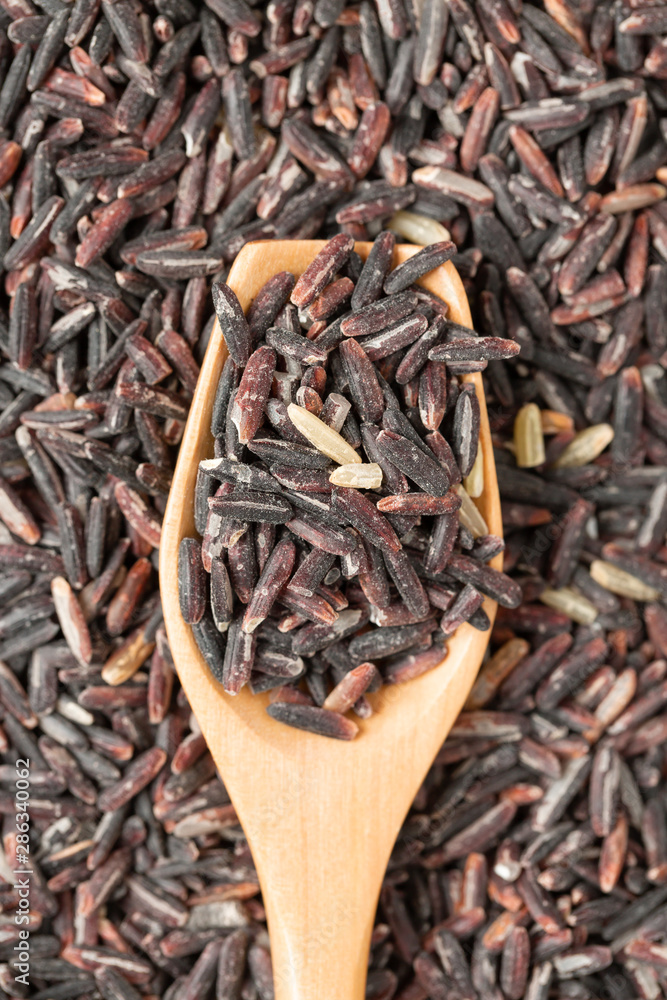 Close up of black rice on wood spoon, Top view Close up of black rice on wood spoon, Top view