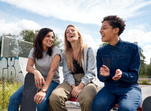 Group Of Female Friends With Skateboard Meeting In Urban Skate Park