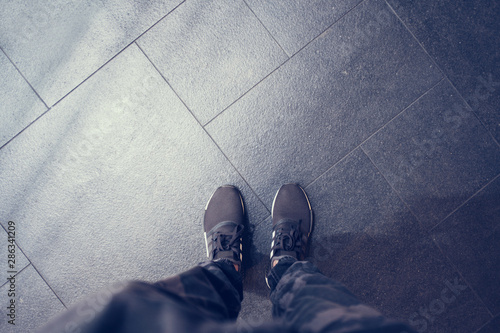 Top view of shoes standing on grey stone floor tiles backgrounds