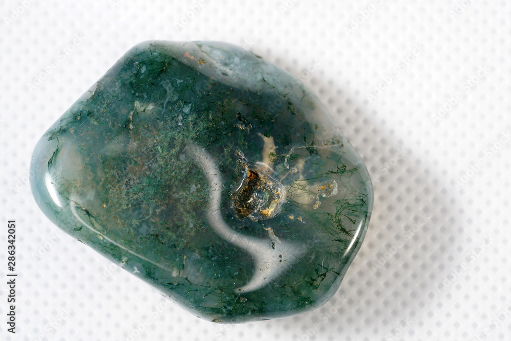 Moss Agate is a type of chalcedony that contains minerals of green color in the stone, formed in filaments and other structures of moss.  - obrazy, fototapety, plakaty 