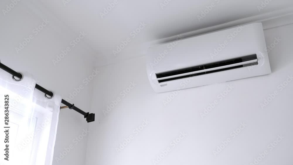 Flat air conditioner on white wall in room. Closeup Flat air conditioner on white wall in room. Closeup