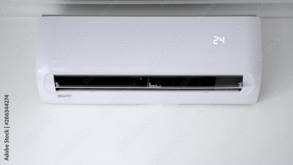 Flat air conditioner on white wall in room. Closeup Flat air conditioner on white wall in room. Closeup