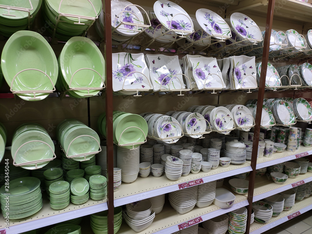 Dishes and bowls are sold on shelves in a supermarket. Organized by category to facilitate customers.