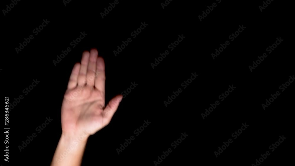 White caucasian male raising his right hand to indicate the commonly known STOP sign expressing rejection. Close up shot of the forearm taken indoor in front of a black background. White caucasian male raising his right hand to indicate the commonly known STOP sign expressing rejection. Close up shot of the forearm taken indoor in front of a black background.
