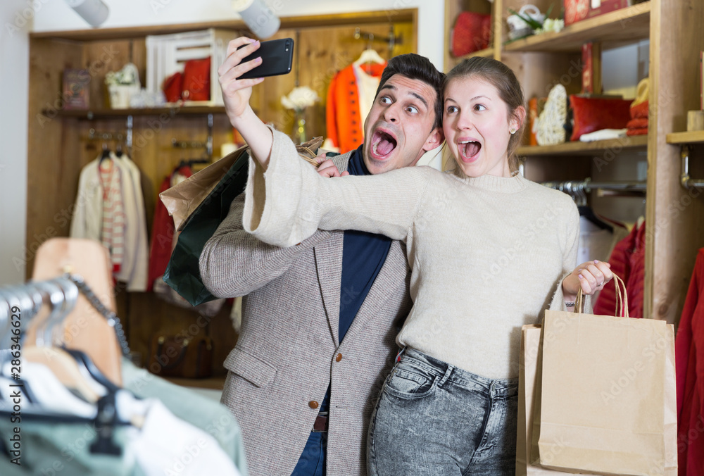Fototapeta premium Couple is satisfied shopping and taking selfie