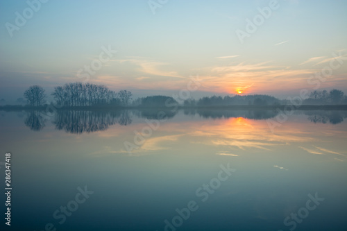 Fototapeta Naklejka Na Ścianę i Meble -  Hazy blue lake and sunset