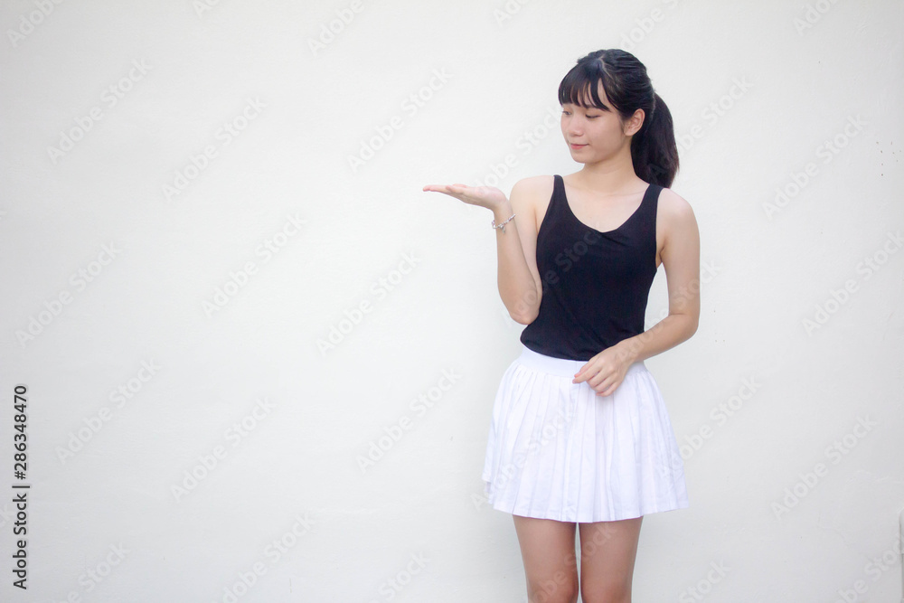Portrait of thai adult beautiful girl black shirt white skirt show hand Portrait of thai adult beautiful girl black shirt white skirt show hand