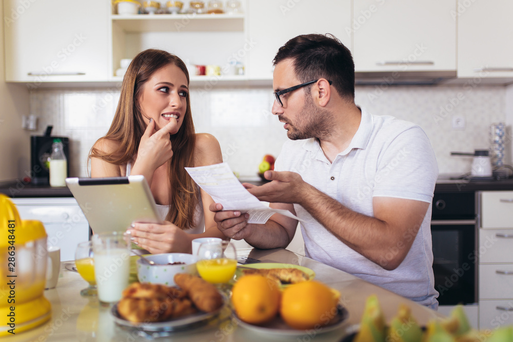 Couple discussing about home budget in the kitchen. Couple discussing about home budget in the kitchen.