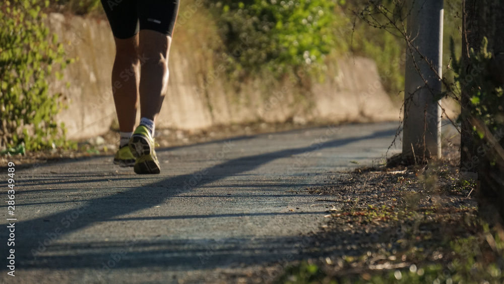 Obraz premium running at the park with a warm morning light, runner on a blurry country background