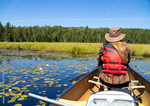 Outdoors woman in canoe on Canadian lake © IHX
