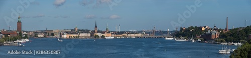 Stockholm buildings at the bay Riddarfjärden between the district Södermalm, Kunsholmen, Gamla Stan and Riddarholmen at sunset with a low sun and fogg torning up in the archipelago