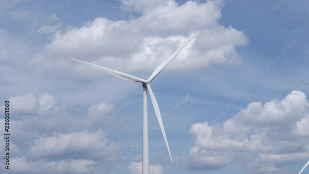 Wind turbine spins around for generating energy with clouds Wind turbine spins around for generating energy with clouds