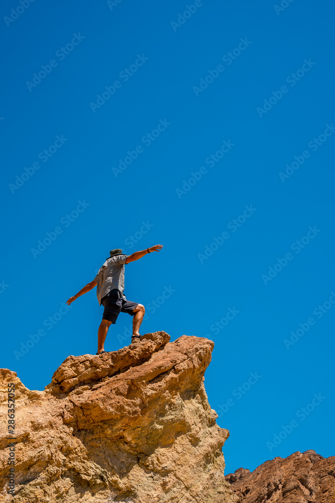 A man on the Golden Canyon trail on top of a beautiful stone, California. United States