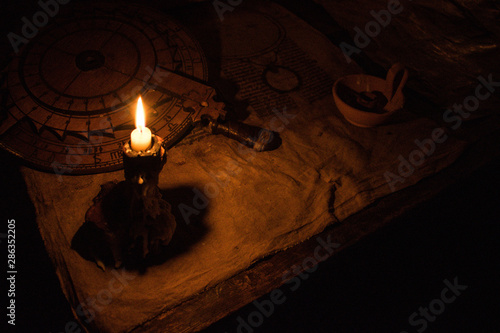 Ancient medieval instruments illuminated by a candle