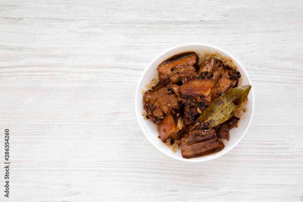 Homemade Filipino Adobo Pork on a white wooden surface, top view. Flat lay, from above, overhead. Space for text. Homemade Filipino Adobo Pork on a white wooden surface, top view. Flat lay, from above, overhead. Space for text.