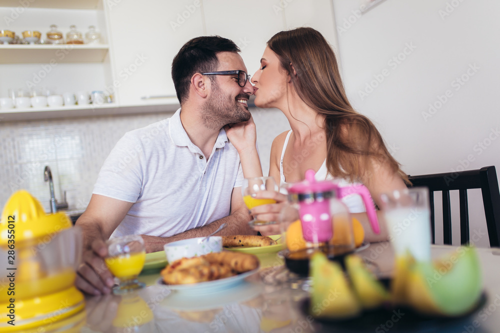 Happy couple enjoying breakfast time together at home.