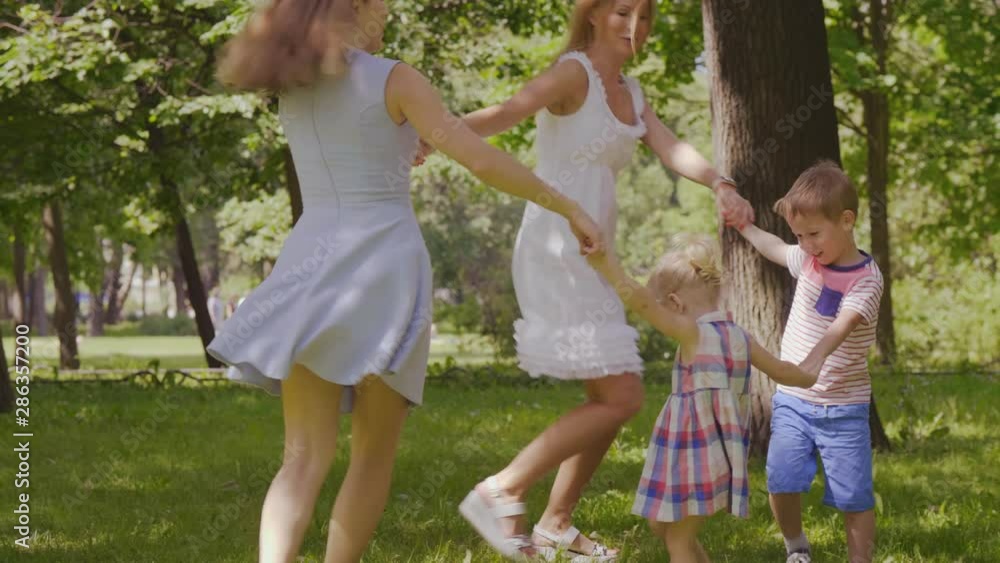 Young mothers and kids dancing in circle Young mothers and kids dancing in circle