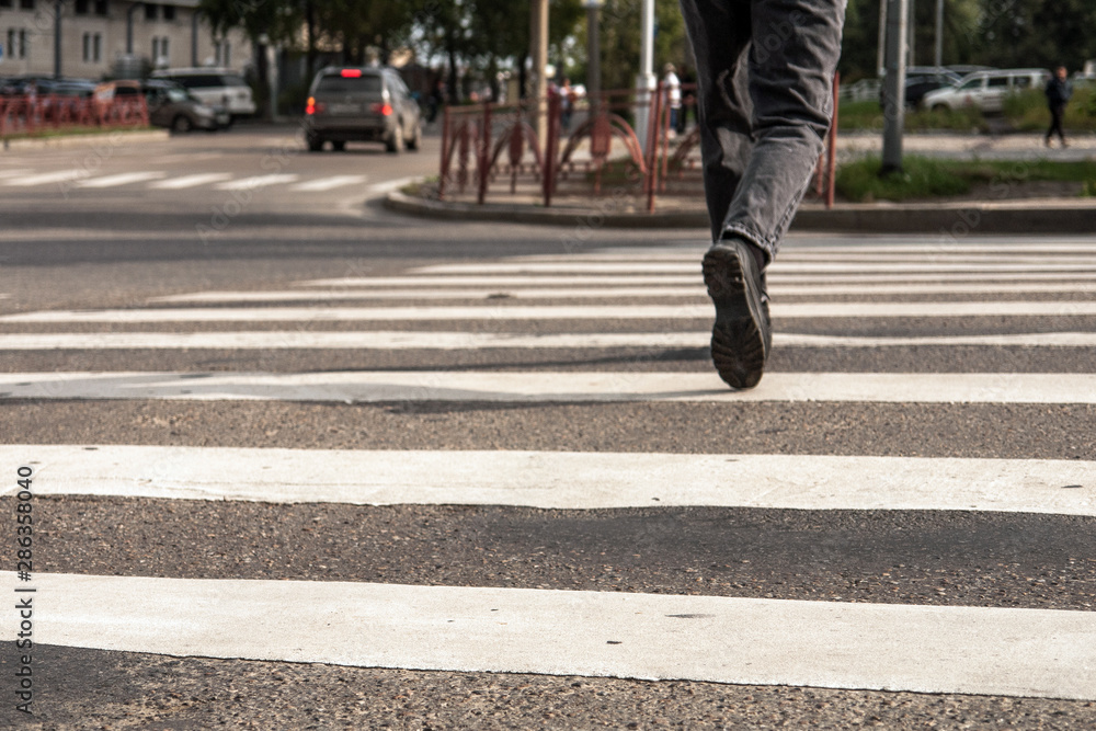 men's legs are on the pedestrian crossing