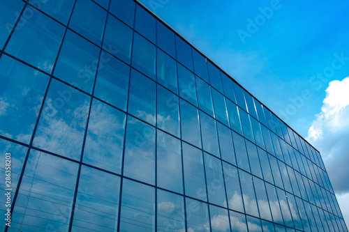 reflection of the blue sky in the Windows of the business center close-up