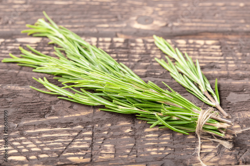 cut rosemary leaves on old wooden table