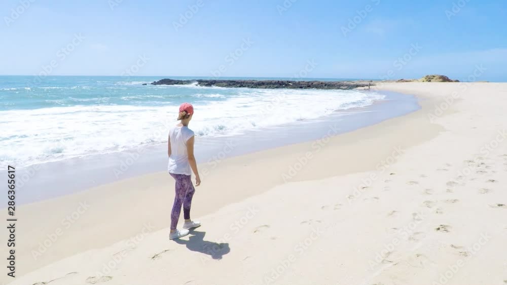 Young woman walking on a beach on West Coast, USA. Adventure and travel concept Young woman walking on a beach on West Coast, USA. Adventure and travel concept