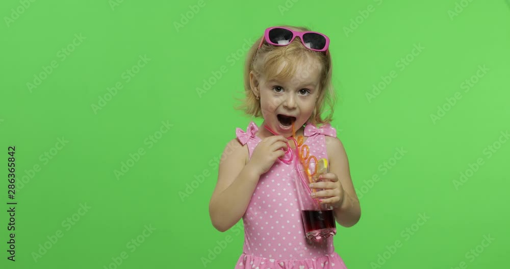 Child in pink swimsuit drinks juice cocktail with drinking straw. Chroma Key Child in pink swimsuit drinks juice cocktail with drinking straw. Chroma Key