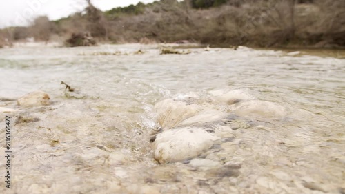 Fly Fisher hikes and fishes a limestone riverbed on the Medina River in the Texas Hill Country. photo