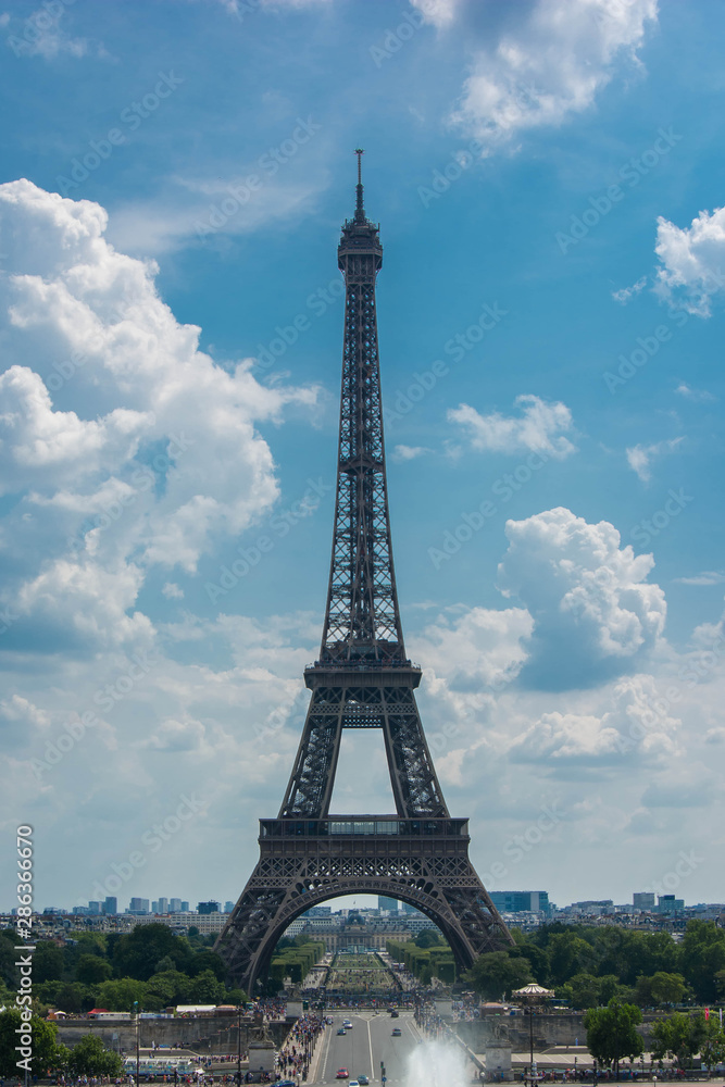 Fototapeta premium Eiffel tower over a blue cloudy sky